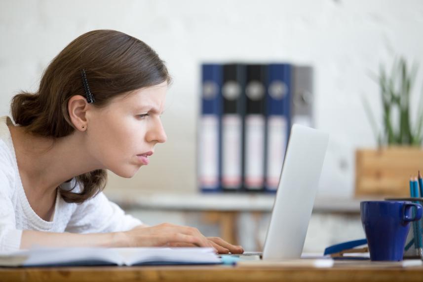 Woman squinting to see her laptop